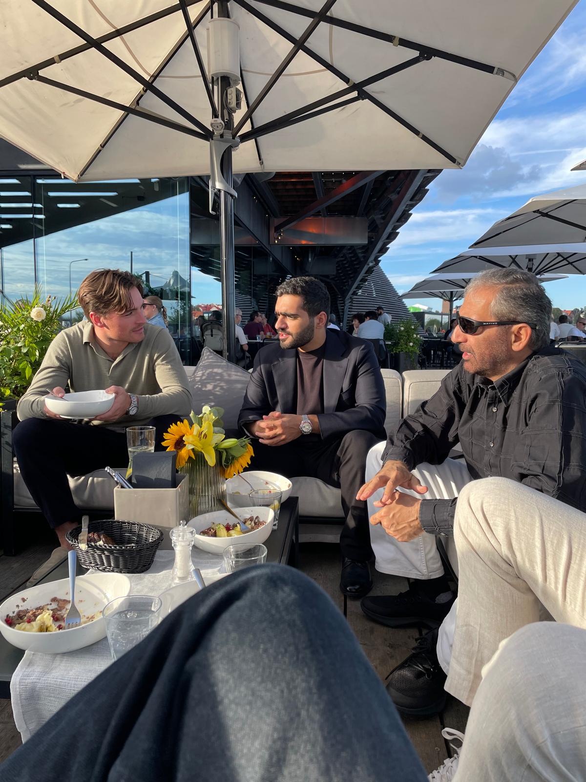 Members in conversation over a shared meal on a Helsinki rooftop